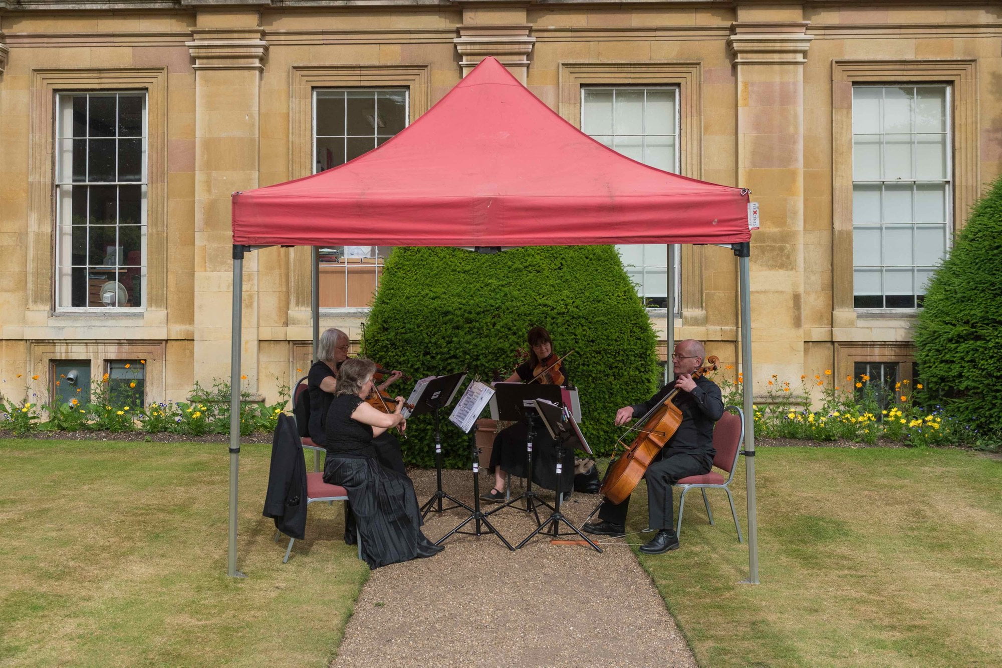 String quartet performing under a gazebo outdoors